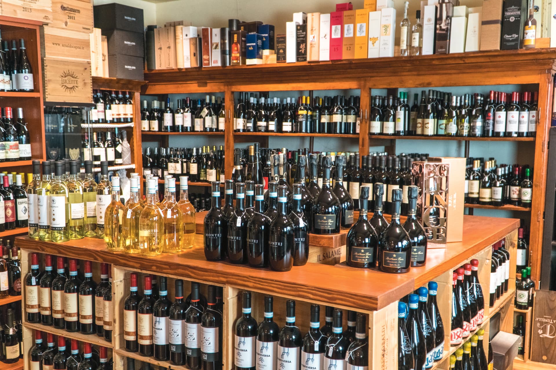 Cantina dell'enoteca con scaffali di bottiglie e casse di legno